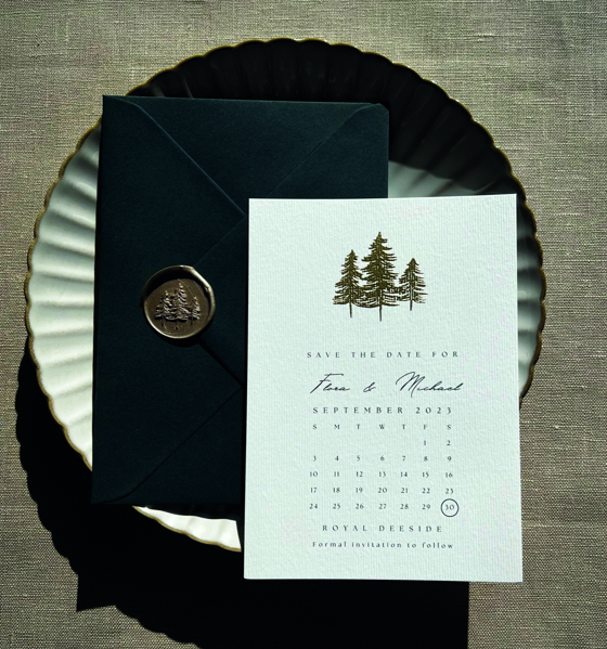 White save the date with embossed trees and black envelope with wax seal and tree detail